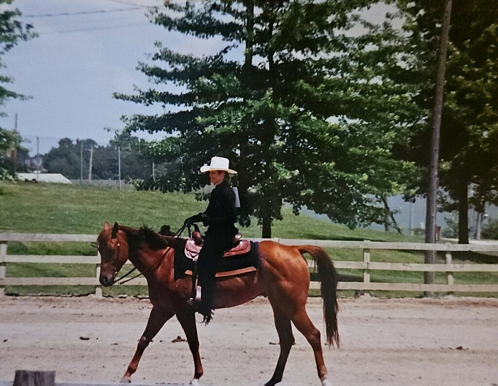 Kelly Swingle pictured riding a horse on her horse ranch.